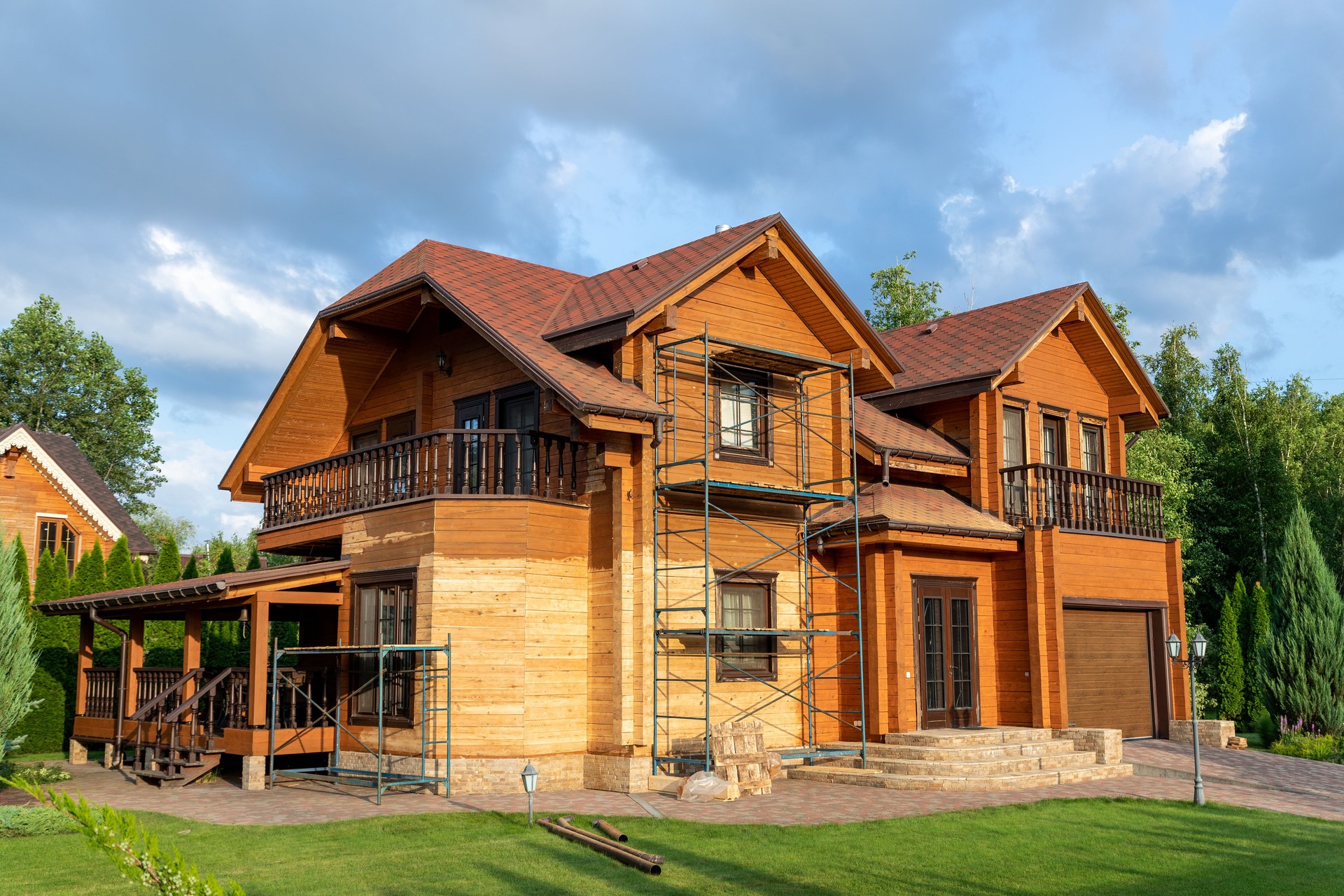 Modern wooden timber eco house villa facade during process of renovation, sanding wall for varnishing against sun burn, bark beetle moisture at countryside villa. Home exterior repair and maintenance